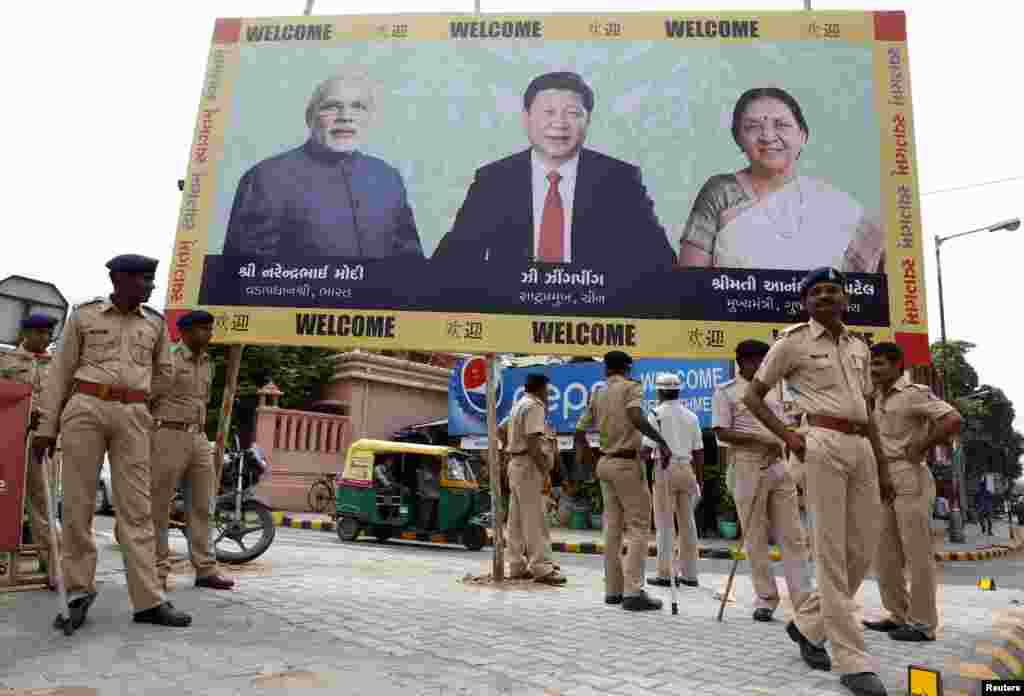 Police personnel stand guard in front of a billboard with images of&nbsp;India&#39;s Prime Minister Narendra Modi, China&#39;s President Xi Jinping and Anandiben Patel, Chief Minister of the western Indian state of Gujarat, ahead of Xi&#39;s arrival in Ahmedabad, Sept. 16, 2014. 