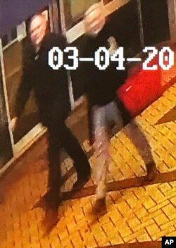 In this image taken from security camera footage from PA shows a man and woman as they walk through an alleyway connecting a Zizzi's restaurant to a bench where former Russian double agent Sergei Skripal was found in Salisbury on Sunday March 4, 2018 .