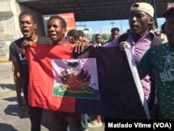 Protesters hold red and black flags during protest in downtown Port au Prince, Haiti on Nov. 18, 2018.