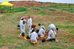 FILE - Workers start the exhumation process of a mass grave in Iraq's northwestern region of Sinjar, March 15, 2019. U.N. investigators have collected records implicating Islamic State militants in atrocities committed against Yazidis.