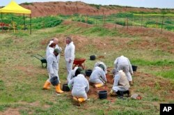 FILE - Workers start the exhumation process of a mass grave in Iraq's northwestern region of Sinjar, March 15, 2019. U.N. investigators have collected records implicating Islamic State militants in atrocities committed against Yazidis.