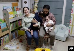 In this March 25, 2019 photo, a South Korean woman Seo Hyo Sun, left, speaks during an interview at her home in Buchon, South Korea. Every baby born in South Korea last year considered to be 2 on Jan. 1. (AP Photo/Lee Jin-man)