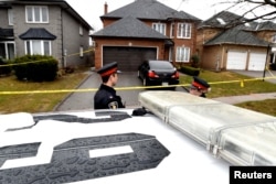 Police officers wait for a search warrant in front of the home of Alek Minassian, in Richmond Hill, Ontario, April 25, 2018.