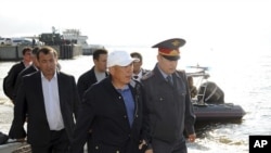 Tatarstan President Rustam Minnikhanov (2nd R front) walks along the bank of the Volga river during the operation to search for the missing people from the tourist boat "Bulgaria" in Russia's Tatarstan region July 11, 2011.