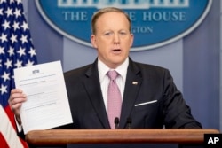 White House press secretary Sean Spicer holds up a Trump Administration document to "repeal and replace Obamacare" as he talks to the media during the daily press briefing at the White House in Washington, March 10, 2017.