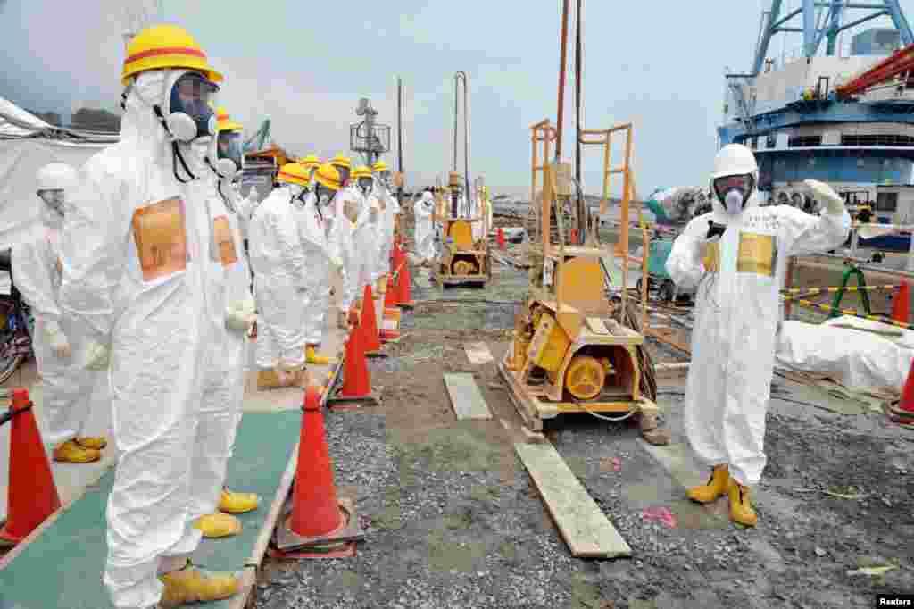 Members of a Fukushima prefecture panel inspect the construction site of the shore barrier, which is meant to stop radioactive water from leaking into the sea, near the No. 1 and No. 2 reactor building of the Fukushima Daiichi nuclear power plant, August 6, 2013.