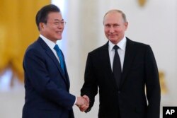 Russian President Vladimir Putin, right, welcomes South Korean President Moon Jae-in prior to their meeting at the Kremlin, in Moscow, Russia, June 22, 2018.