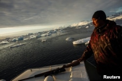 Cahaya matahari terbenam menyinari wajah pemburu anjing laut, Henrik Josvasson, dekat Kota Tasiilaq, Greenland, 16 Juni 2018.(Foto: Reuters)