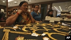 A customer tries on a gold necklace inside a jewellery showroom in the southern Indian city of Hyderabad, April 11, 2012.