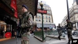 1月10日，法國軍人在巴黎街頭一家超市附近巡邏，加強戒備。