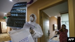 This photo taken on February 3, 2020 shows a doctor looking at a lung CT image. He is visiting patients in quarantine at a hospital in Wuhan, China. (Photo by STR / AFP)