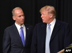 FILE - President Donald Trump speaks with Boeing CEO Dennis Muilenburg during a tour of the Boeing Company in St. Louis, Missouri, March 14, 2018.