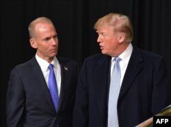 Dalam foto arsip ini yang diambil tanggal 14 Maret 2018, tampak Presiden Trump berbicara dengan Kepala Eksekutif Boeing, Dennis Muilenburg, dalam sebuah kunjungan ke Boeing Company di St. Louis, Missouri.