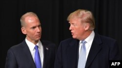 In this file photo taken on March 14, 2018, President Donald Trump speaks with Boeing CEO Dennis Muilenburg during a tour of the Boeing Company in St. Louis, Missouri. 