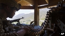 Staff Sergeant Benjamin George, 26, of Kalihi, Hawaii, stands guard in a watchtower at Combat Outpost Pirtle King in Kunar province, Afghanistan, July 6, 2011