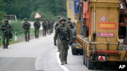 Polish soldiers, part of the peacekeeping mission in Kosovo KFOR, patrol near the northern Kosovo border crossing of Jarinje, along the Kosovo-Serbia border, Oct. 2, 2021. 