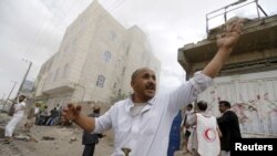 People react at the site of a Saudi-led coalition airstrike in Sana'a, Yemen, April 8, 2015. 