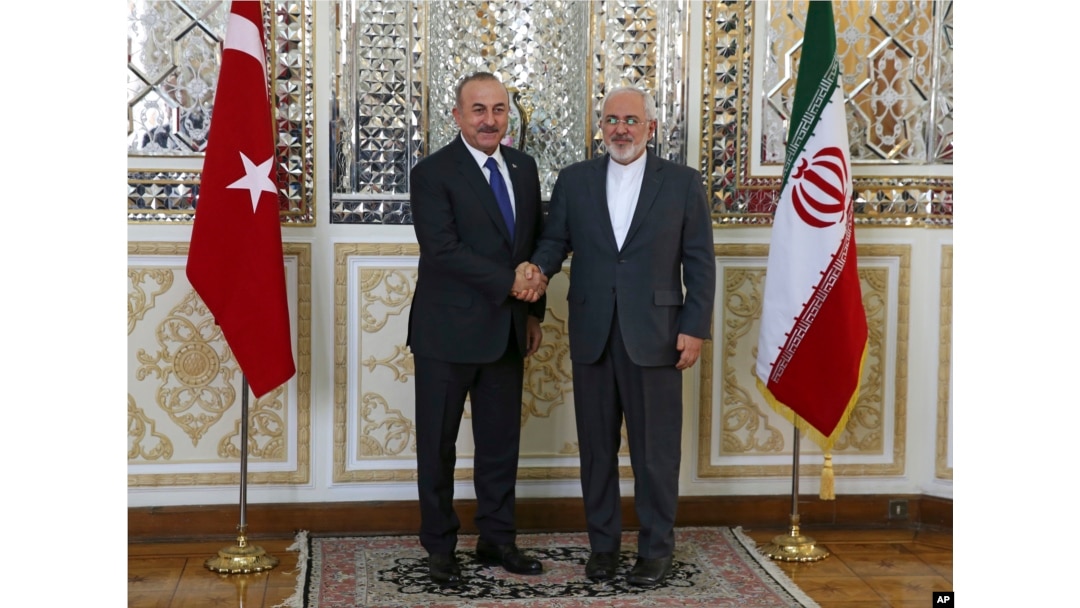 Iranian Foreign Minister Mohammad Javad Zarif, right, and his Turkish counterpart Mevlut Cavusoglu shake hands for journalists at the start of their meeting, in Tehran, Iran, Feb. 7, 2018.