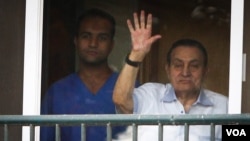 FILE - Ousted President Hosni Mubarak waves to supporters outside his hospital room where he awaits his final retrial for the deaths of hundreds of protesters during the 2011 uprising, Cairo, Oct. 6, 2015. (H.Elrasam/VOA) 