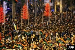 Libyans wave national flags as they attend a celebration marking the seventh anniversary of the Libyan revolution which toppled late leader and strongman Moamer Kadhafi, in the capital Tripoli's Martyrs Square, Feb. 17, 2018.