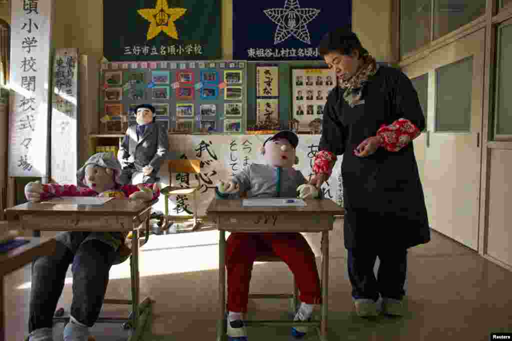 Tsukimi Ayano stands in a classroom with scarecrows at a closed down school in the village of Nagoro on Shikoku Island. The tiny village in southern Japan is teeming with Ayano&#39;s hand-sewn creations.