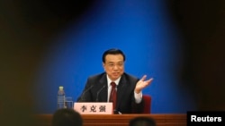 China's newly-elected Premier Li Keqiang gestures during his news conference in Beijing, March 17, 2013.