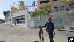A Syrian security man stands guard in front of the U.S. embassy in Damascus, Syria, July 12 2011. (file photo)