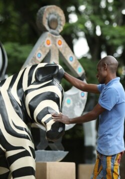 Zimbabwean sculptor Dominic Benhura polishes one of his works at his studio in Harare