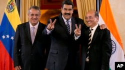 Venezuela's President Nicolas Maduro, center, and Executive Director of Oil and Natural Gas Corporation, el jefe de estado afirmó que solicitó al ministro de Petróleo, Eulogio Del Pino (derecha), tomar acciones legales ante las recientes informaciones que publicó JP Morgan.