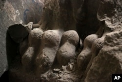 Ancient destroyed artifacts are seen inside Mosul's heavily damaged museum, March 8, 2017. The floors were covered in the ashes of ancient manuscripts.