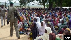 A policeman walks past dozens of people, who have been displaced from their communities after attacks by the Islamist group Boko Haram, at a camp for internally displaced people in Maiduguri, August 3, 2015. 