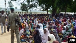 Un policier passant des personnes déplacées par les attaques à Maiduguri (Archives)