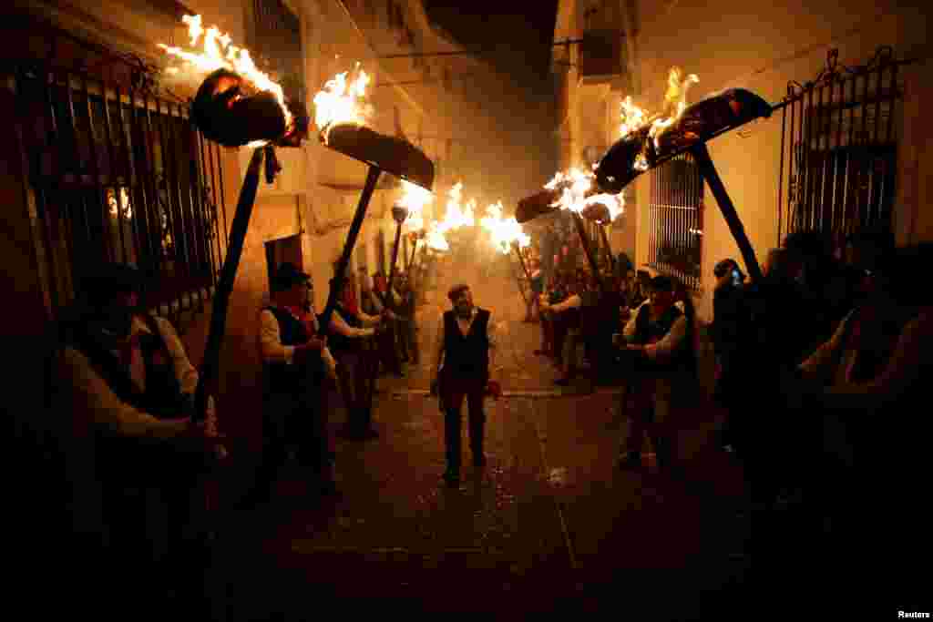 Villagers hold torches to represent light and vision during the Divina Pastora procession, as part of a festival to honor the Virgin of Los Rondeles, on the eve of St. Lucia&#39;s Day, in Casarabonela, near Malaga, southern Spain, Dec. 12, 2017.
