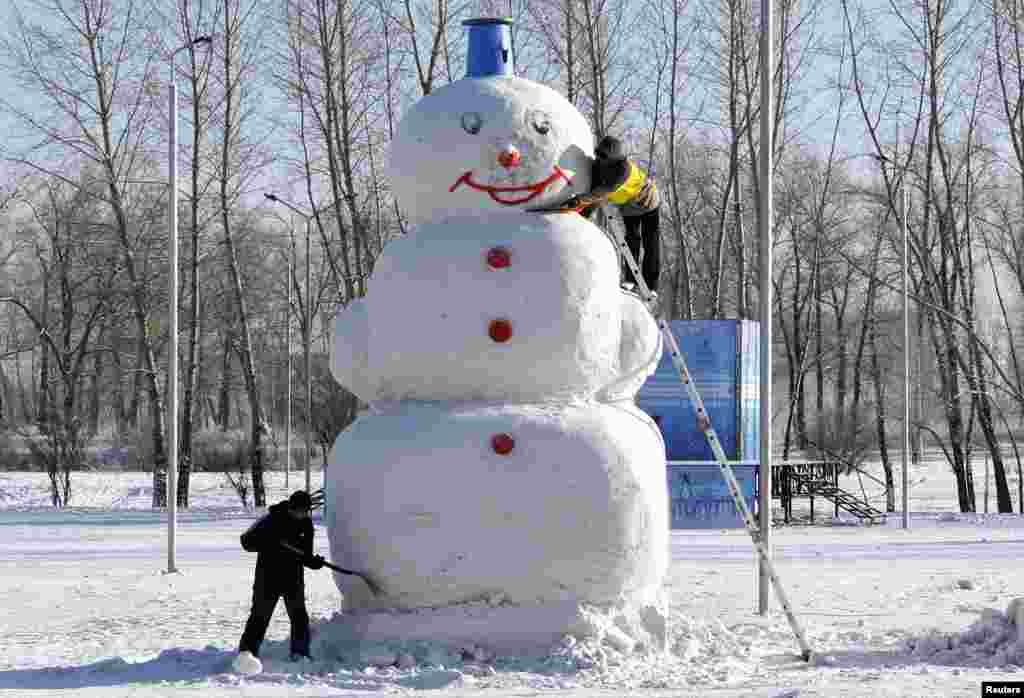 Men work on a 5-meter-high snowman at a park in the Siberian city of Krasnoyarsk, Russia.
