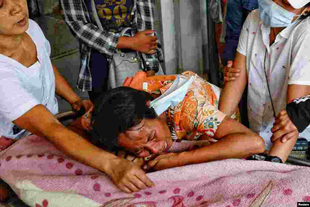 Family members cry over the dead body of a teenage boy Tun Tun Aung who was shot dead by security forces in front of his home in Mandalay, Myanmar.