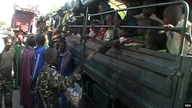 FILE - Nigerian refugees are seen on a Cameroonian military truck set to make its way out of Fotokol for Nigeria, in Fotokol, Cameroon, April 19, 2017. (M.E. Kindzeka/VOA)