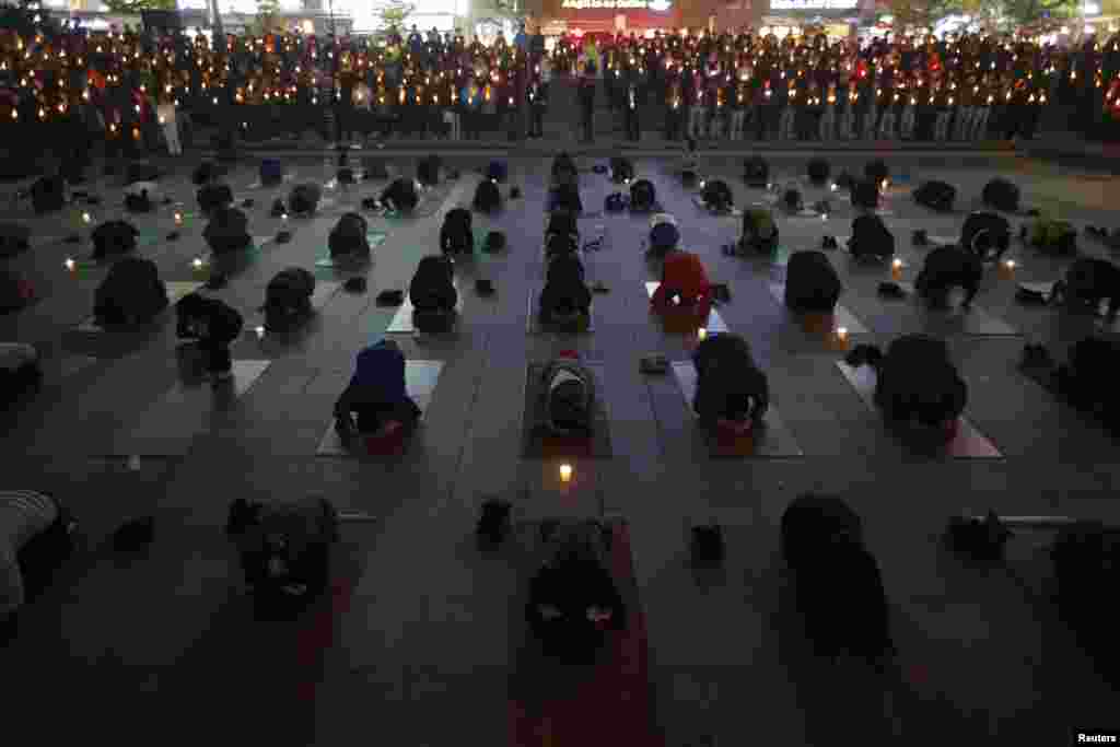 People pray during a candlelight vigil in Ansan, South Korea, April 23, 2014.