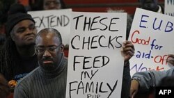 Nezaposleni Amerikanac sa natpisom "tim čekovima hranim porodicu" protestuje protiv ukidanja finansijske nadokande za nezaposlene