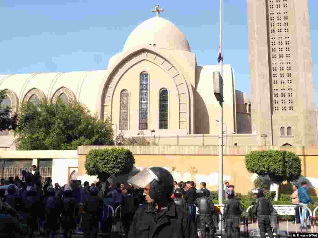 Polisi huru-hara menjaga katedral sambil memblokir jalan yang mengarah ke kompleks katedral di Abassya, Kairo (11/12).