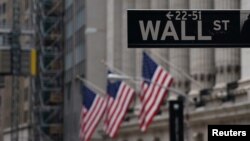 FILE - The Wall Street sign is pictured in front of the New York Stock Exchange in New York City.
