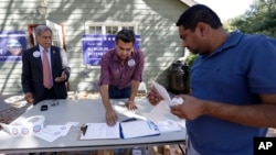 Shahul Feroze (R) gets information from campaign volunteers during a voter registration drive in Basking Ridge, New Jersey, Sept. 23, 2016. Many U.S. Muslims were mobilized to register in response to anti-Muslim rhetoric by Republican candidate Donald Trump.