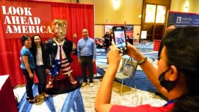 Người tham dự hội nghị chụp hình với bức tượng vàng cựu Tổng thống Donald Trump tại Hội nghị Hành động Chính trị Bảo thủ (CPAC), ngày 27 tháng 2, 2021, Orlando, Florida, ngày 27 tháng 2, 2021.