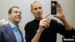 Apple chief executive Steve Jobs (R) shows an iPhone 4 to Russia's President Dmitry Medvedev during his visit to Silicon Valley in Cupertino, June 23, 2010.