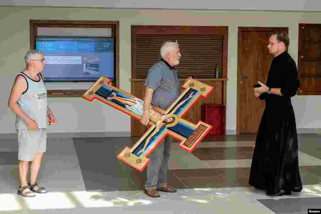 A man carries wooden cross at Catholic Primary School in Rzeszow, Poland, Sept. 2, 2019.