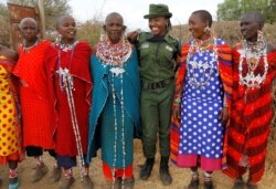 Sharon Karaine, anggota Team Lioness, sebuah unit ranger Kenya yang semuanya perempuan, disambut oleh wanita Maasai dengan kostum tradisional saat ia pulang dari kamp Risa, Amboseli, Kenya, 8 Agustus 2020. (Foto: REUTERS/Njeri Mwangi)