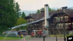 This Sept. 3, 2017 photo provided by the National Park Service shows fire truck positioned outside Lake McDonald Lodge in Glacier National Park, Montana, as firefighters prepare for a blaze that is threatening the century-old Swiss chalet-style hotel. 