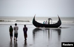 People look at a boat that capsized with a group of Rohingya refugees in it at Bailakhali, near Cox's Bazar, Bangladesh, Oct. 31, 2017.