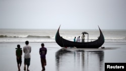 People look at a boat that capsized with a group of Rohingya refugees in it at Bailakhali, near Cox's Bazar, Bangladesh, Oct. 31, 2017.