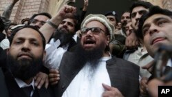 Hafiz Saeed, head of the Pakistani religious party, Jamaat-ud-Dawa, gestures outside a court in Lahore, Pakistan, Nov. 22, 2017. The court rejected the government's plea to extend for three months the house arrest of Saeed, the former leader of a banned m