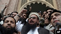 Hafiz Saeed, head of the Pakistani religious party, Jamaat-ud-Dawa, gestures outside a court in Lahore, Pakistan, Nov. 22, 2017. 
